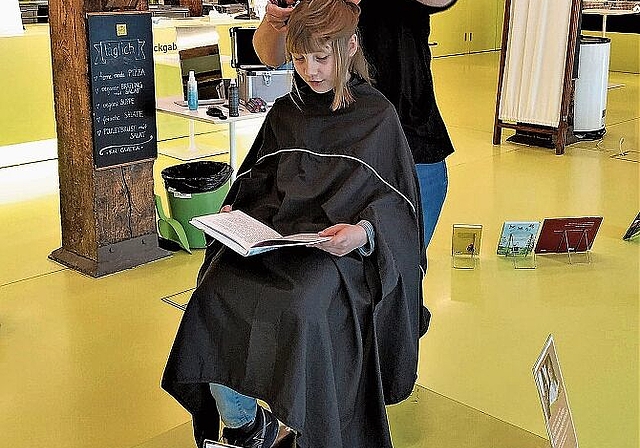 Sabine Schneider schneidet die Haare der neunjährigen Anna, während diese laut vorliest. Fotos: S. van Riemsdijk

