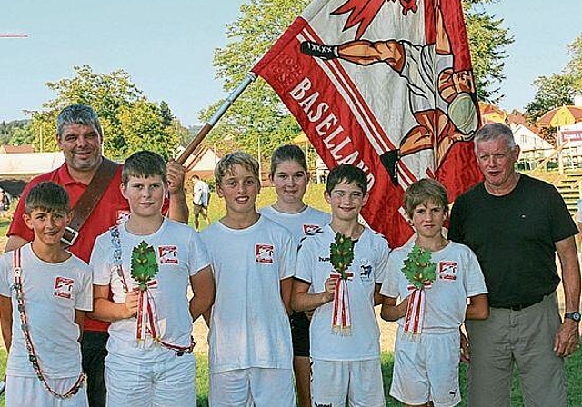 Vorne von links nach rechts: Jan Kaufmann, Elias Buess, Raffael Imhof, Flavia Buess (Betreuerin), Tim Koller, Konstantin Sacher, Rolf Imhof (Trainer). Hinten: Bernhard Imhof, Präsident Nationalturnverband Baselland. Nicht auf dem Bild ist Fynn Dehni