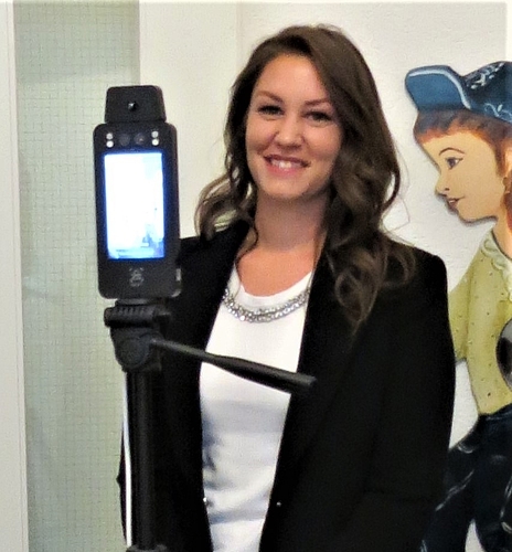 Carmen Nägelin von der Vertriebsfirma nôus by vena GmbH erläutert die Funktion des Körperwärme-Scanners am Eingang der Kindertagesklinik.
