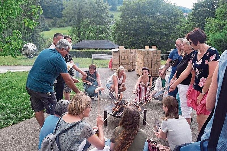 Die Gritt-Mitarbeitenden geniessen beim Bräteln das Zusammensein mit Wurst, Brot und Wein.
