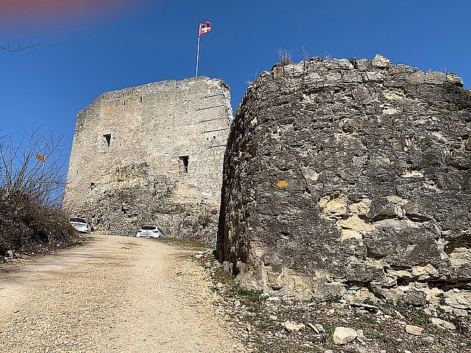Im Hintergrund die mächtige Schildmauer der Farnsburg. Im Vordergrund das Bollwerk mit bröckelndem Mauerwerk. Foto: Archäologie Baselland
