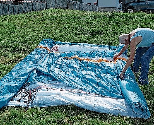 Nach dem Flug wird der Gleitschirm präzis zu einem handlichen Paket zusammen gefaltet.
