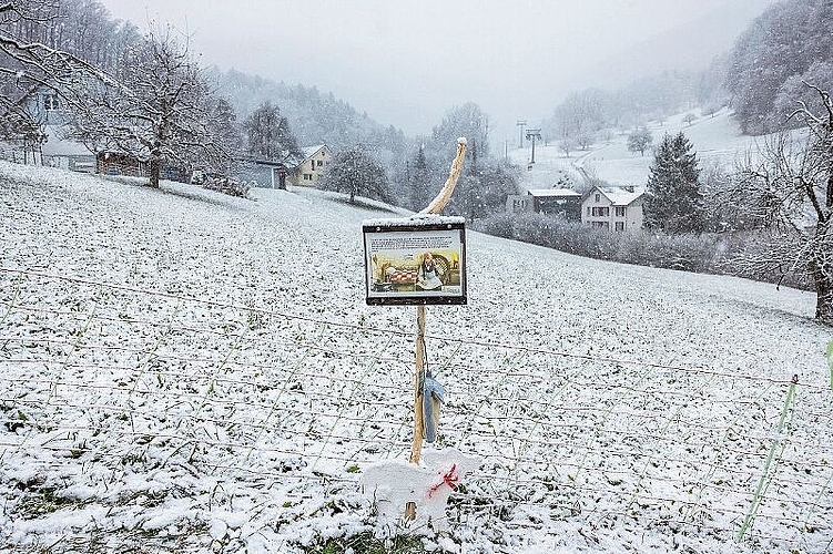 Reigoldswil im weissen Gewand mit dem letzten Posten des Hirtenpfades.