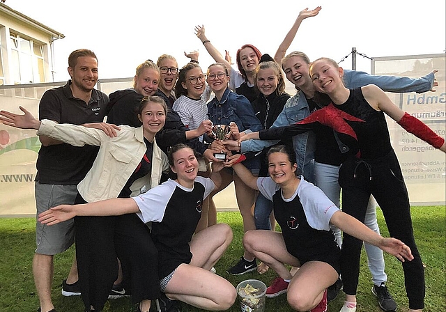 Turnerinnen und Trainer freuen sich über den gewonnen Pokal und den erreichten ersten Platz. Foto: zVg