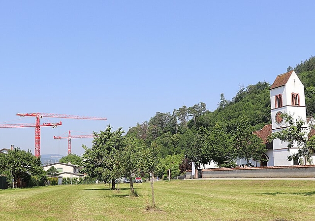 Die Kirche von Lausen stand in dem heute verschwundenen Dorf Bettenach. Links vom Bildausschnitt, unterhalb der Häuserzeile, befand sich ein Stausee aus der Römerzeit, der das Tal bis zur Gemeindegrenze mit Liestal ausfüllte. Dort – auf dem Bild