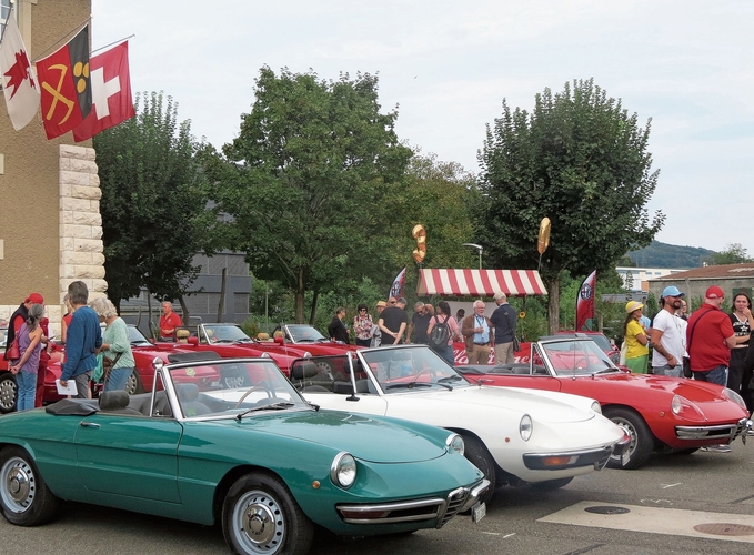 Auf dem Schulhausplatz drei Alfa Romeos in den italienischen Farben. 