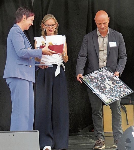 Regierungsrätin Monica Gschwind überreichte dem Vorsitzenden der Geschäftsleitung Daniel Seeholder ein Bild. In der Mitte Moderatorin Anja Weyeneth.