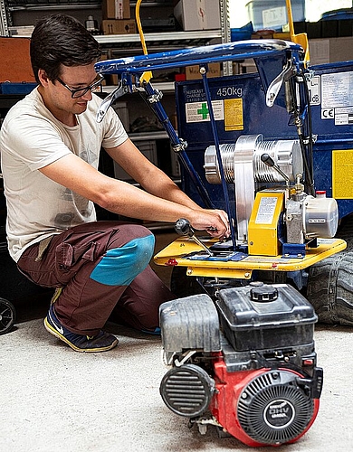 Ein Mitarbeiter des Ökozentrums rüstet einen Raupendumper auf Elektroantrieb um.
