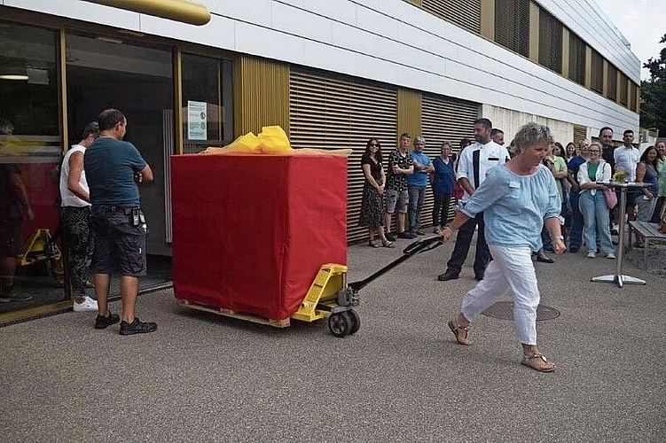 Silke Amend, Mitglied der Zentrumsleitung, präsentiert unter den gespannten Blicken der Gritt-Mitarbeitenden das erste Paket. Fotos: ZVG