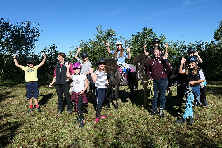 Auf dem Reitplatz freuen sich (v. l.) Ben, Leiterin Sibylle Müller, Anna Sofia, Doreen, Stella, Lynn, Lyam, Co-Leiterin Eileen, Duja, Alisha mit den Ponys und Islandpferden Vanilla, Rökkva, Skjoni und Maja. Foto: U. Handschin