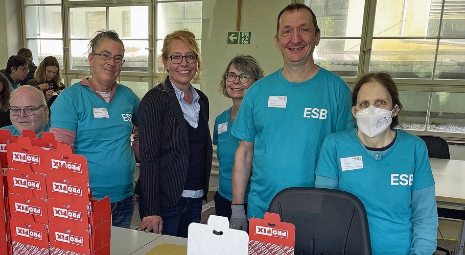 Die Geschäftsleiterin Ursula Aellen (im Blazer) mit motivierten Mitarbeitenden im Bereich Verpackung an der Ribigasse in Hölstein. 