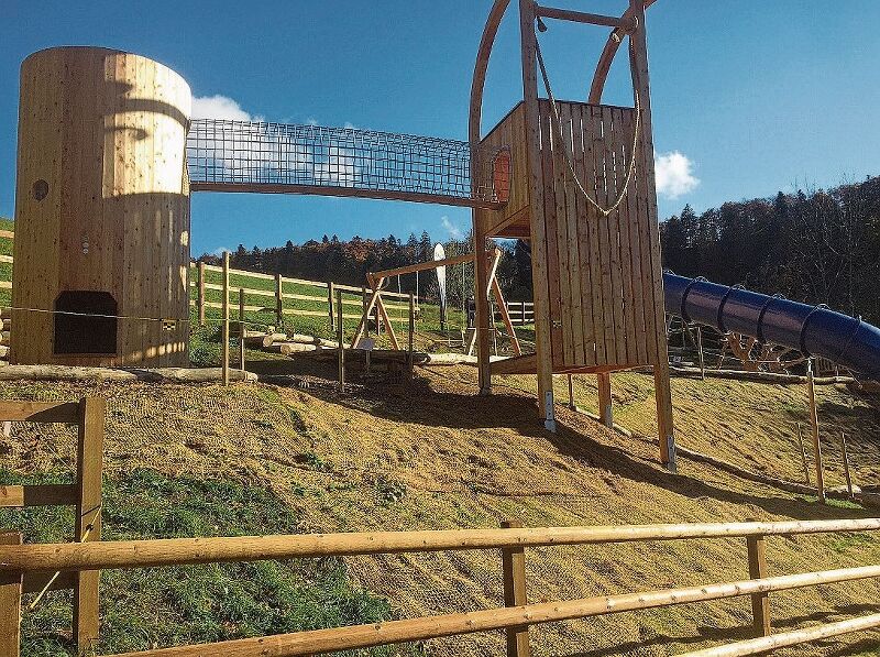 Der Aufstiegsturm (links) und der 7 Meter hohe Schlitten – er ist der Inbegriff für den Wintersport - stellen Glanzlichter der Anlage dar. Sie sind wie allen Geräte aus Lärchenholz gefertigt worden.