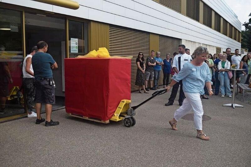 Silke Amend, Mitglied der Zentrumsleitung, präsentiert unter den gespannten Blicken der Gritt-Mitarbeitenden das erste Paket. Fotos: ZVG