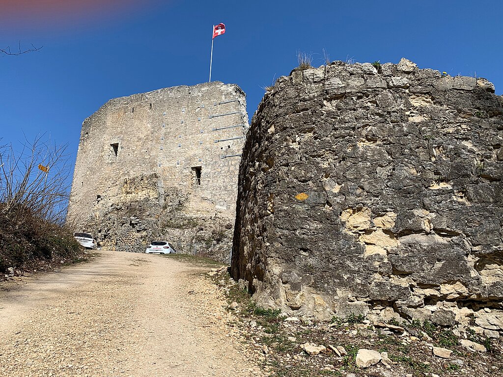 Im Hintergrund die mächtige Schildmauer der Farnsburg. Im Vordergrund das Bollwerk mit bröckelndem Mauerwerk. Foto: Archäologie Baselland
